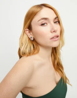 Pendientes bañados en plata en forma de ojo con pestañas y cristal facetado verde