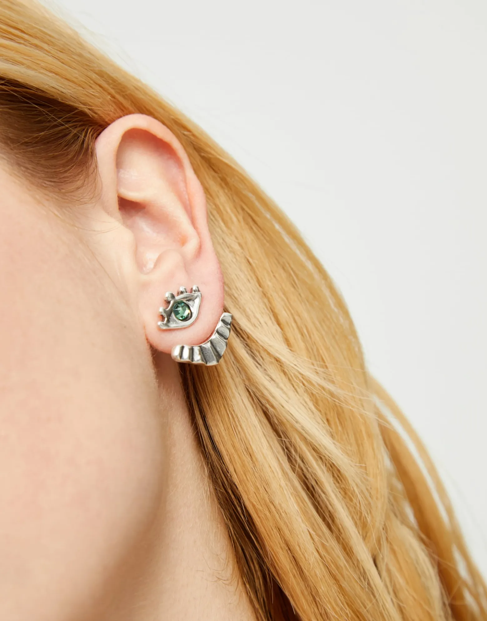 Pendientes bañados en plata en forma de ojo con pestañas y cristal facetado verde