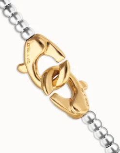Pulsera de bolas pequeñas bañada en oro con mosqueton entrelazado en oro