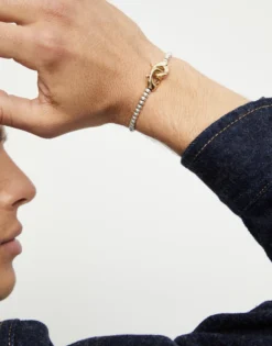 Pulsera de bolas pequeñas bañada en oro con mosqueton entrelazado en oro