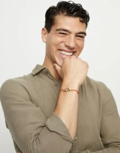 Pulsera de cuero naranja con mosquetón entrelazado en oro