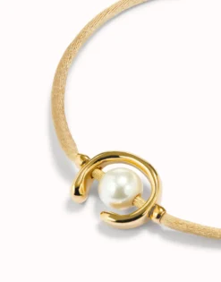 Pulsera de hilo camel con perla shell fornitura bañada en oro 18k.
