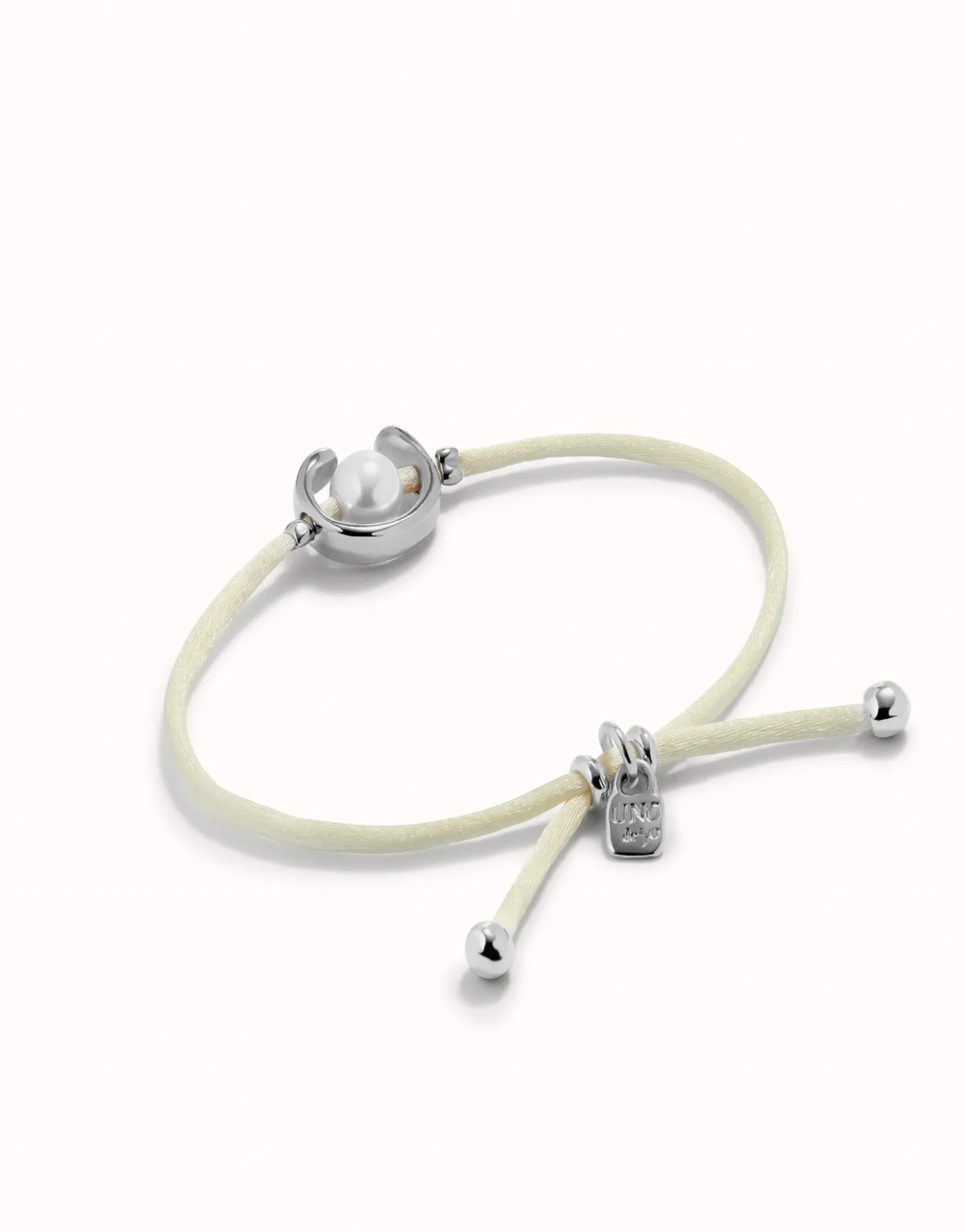 Pulsera de hilo crema con perla shell fornitura bañada en plata de ley.