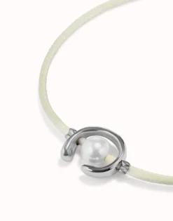 Pulsera de hilo crema con perla shell fornitura bañada en plata de ley.