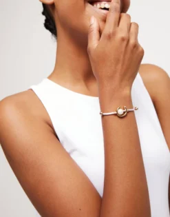 Pulsera de hilo lila con perla shell fornitura bañada en oro 18k.