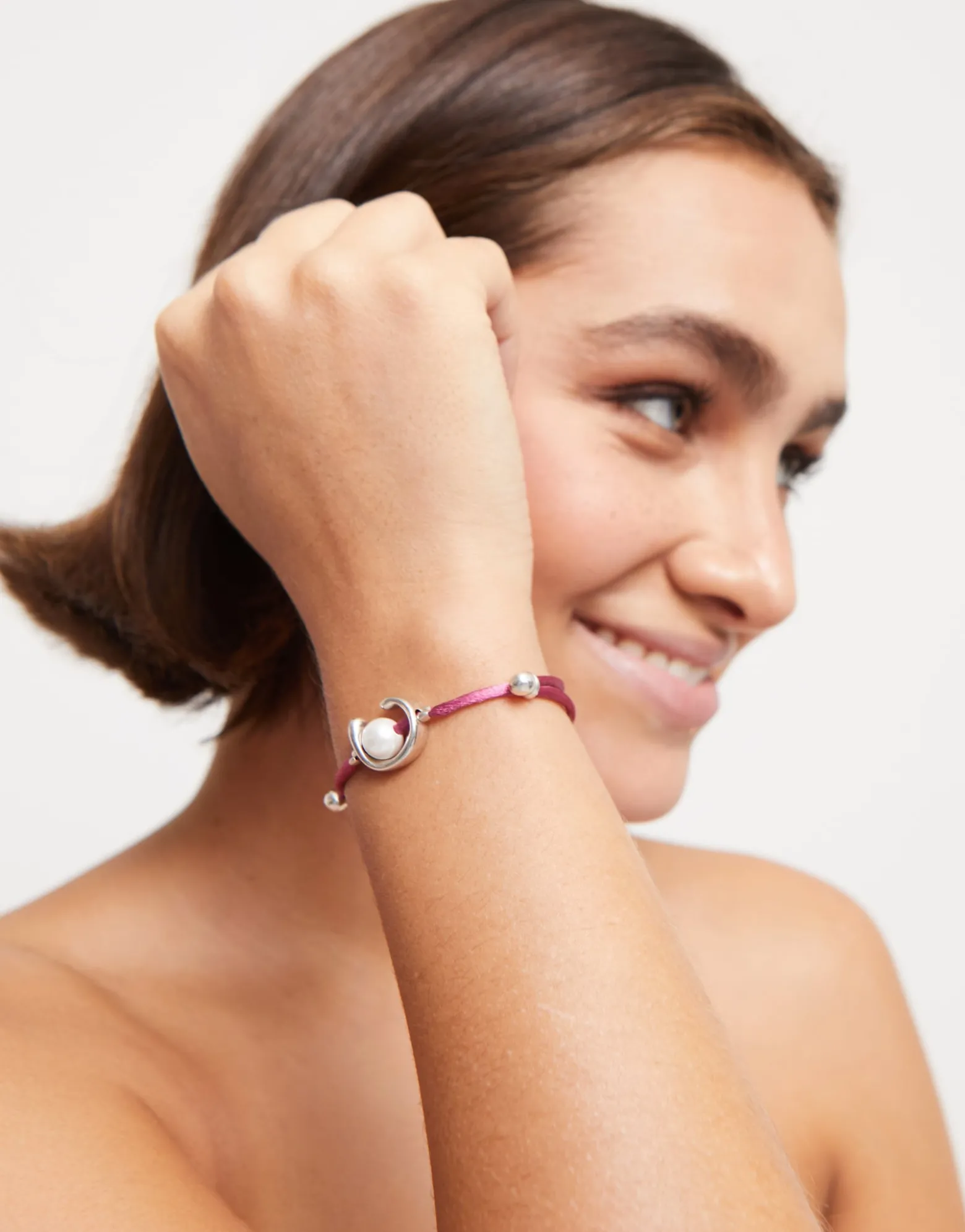 Pulsera de hilo malva con perla shell fornitura bañada en plata de ley.
