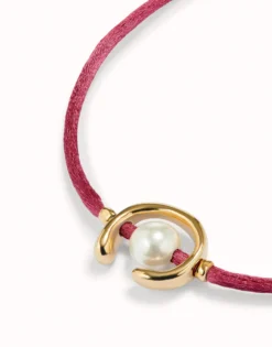 Pulsera de hilo malva con perla shell fornitura bañada en oro 18k.