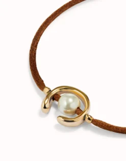 Pulsera de hilo marrón con perla shell fornitura bañada en oro 18k.