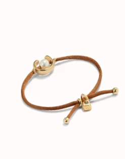 Pulsera de hilo marrón con perla shell fornitura bañada en oro 18k.