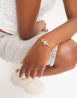 Pulsera de hilo naranja con perla shell fornitura bañada en oro 18k.