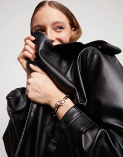 Pulsera de hilo negro con perla shell fornitura bañada en oro 18k.