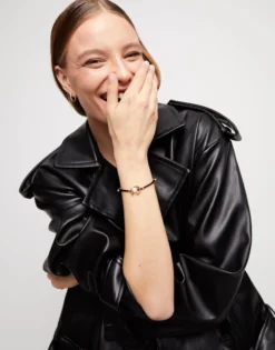 Pulsera de hilo negro con perla shell fornitura bañada en oro 18k.