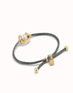 Pulsera de hilo negroso con perla shell fornitura bañada en oro 18k.