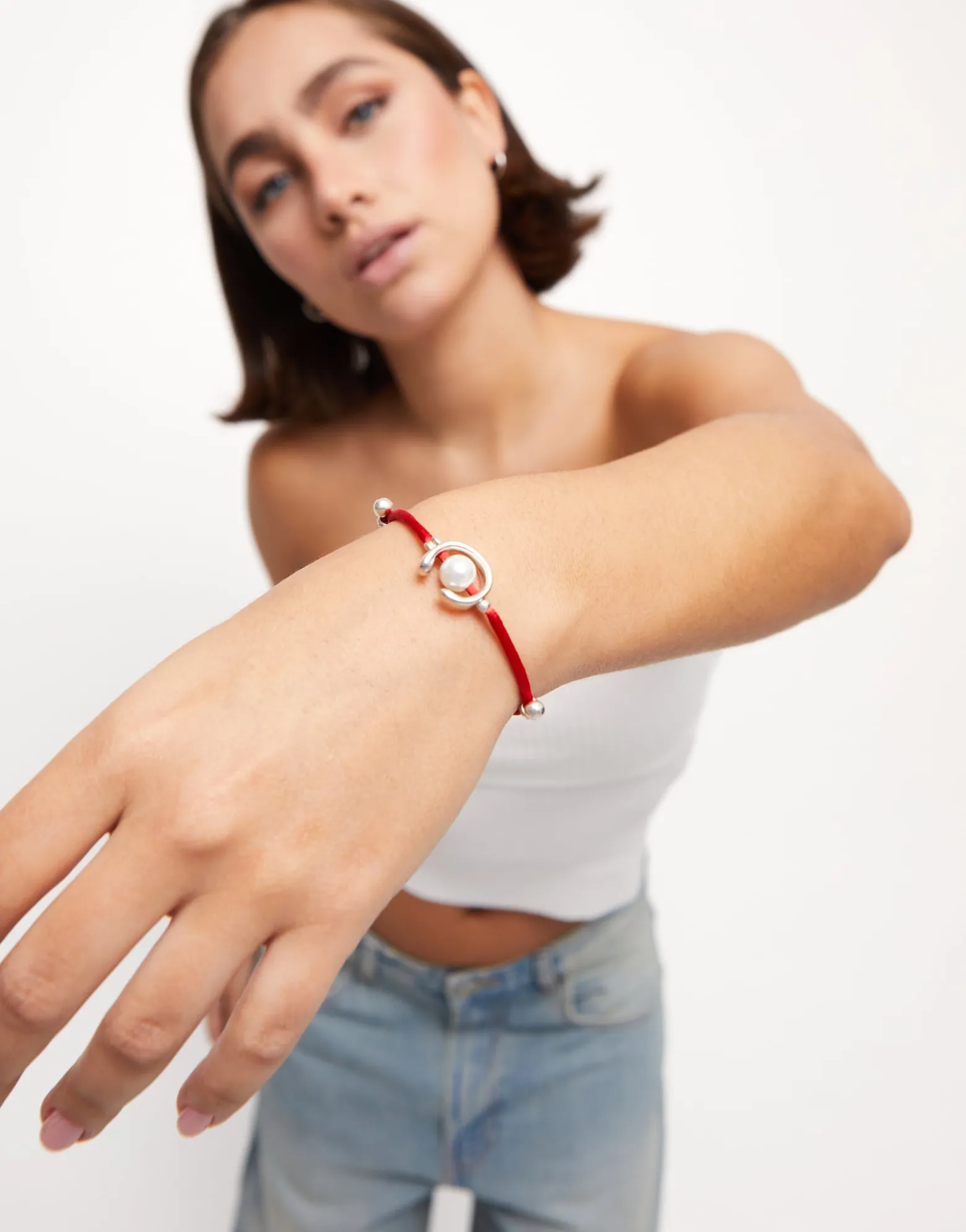 Pulsera de hilo rojo con perla shell fornitura bañada en plata de ley.