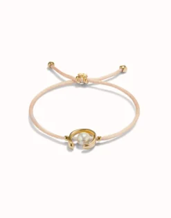 Pulsera de hilo salmón con perla shell fornitura bañada en oro 18k.