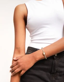 Pulsera de hilo verde azulado con perla shell fornitura bañada en oro 18k.