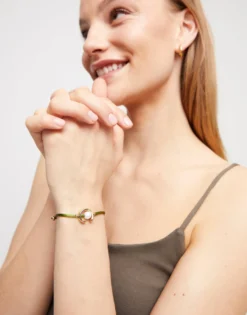 Pulsera de hilo verde oscuro con perla shell fornitura bañada en oro 18k.