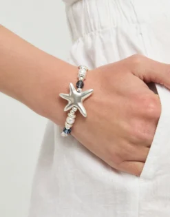Pulsera elástica bañada en plata con cristales azules y estrella de mar