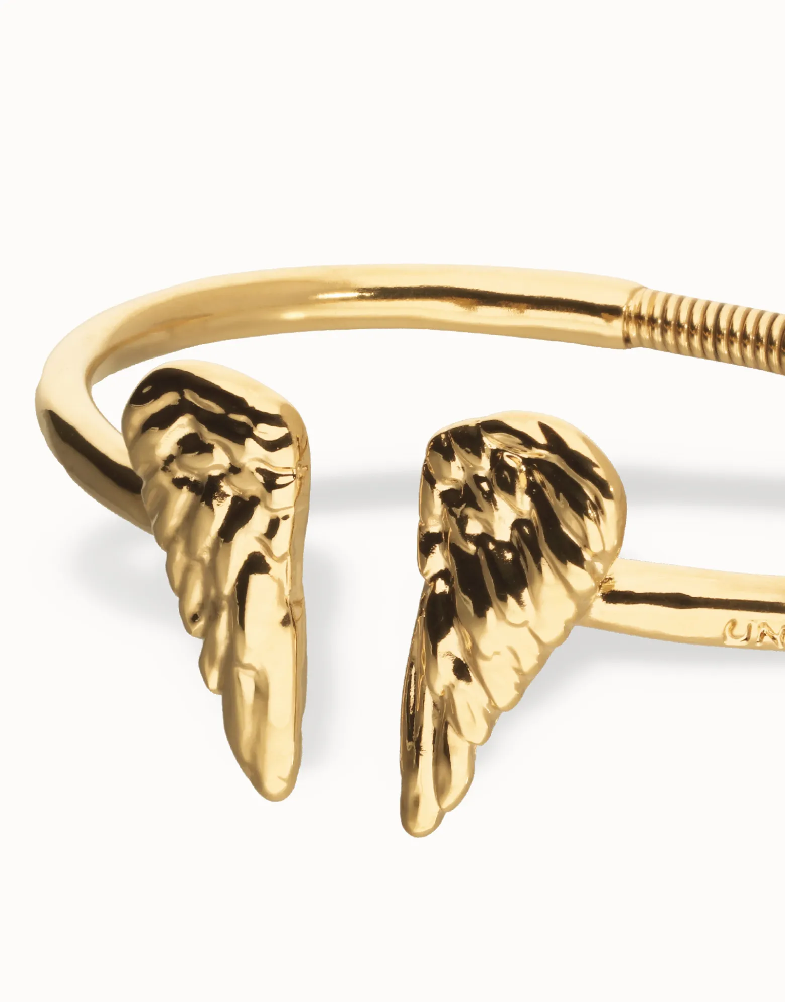 Pulsera rígida bañada en oro 18k con detalle de alas