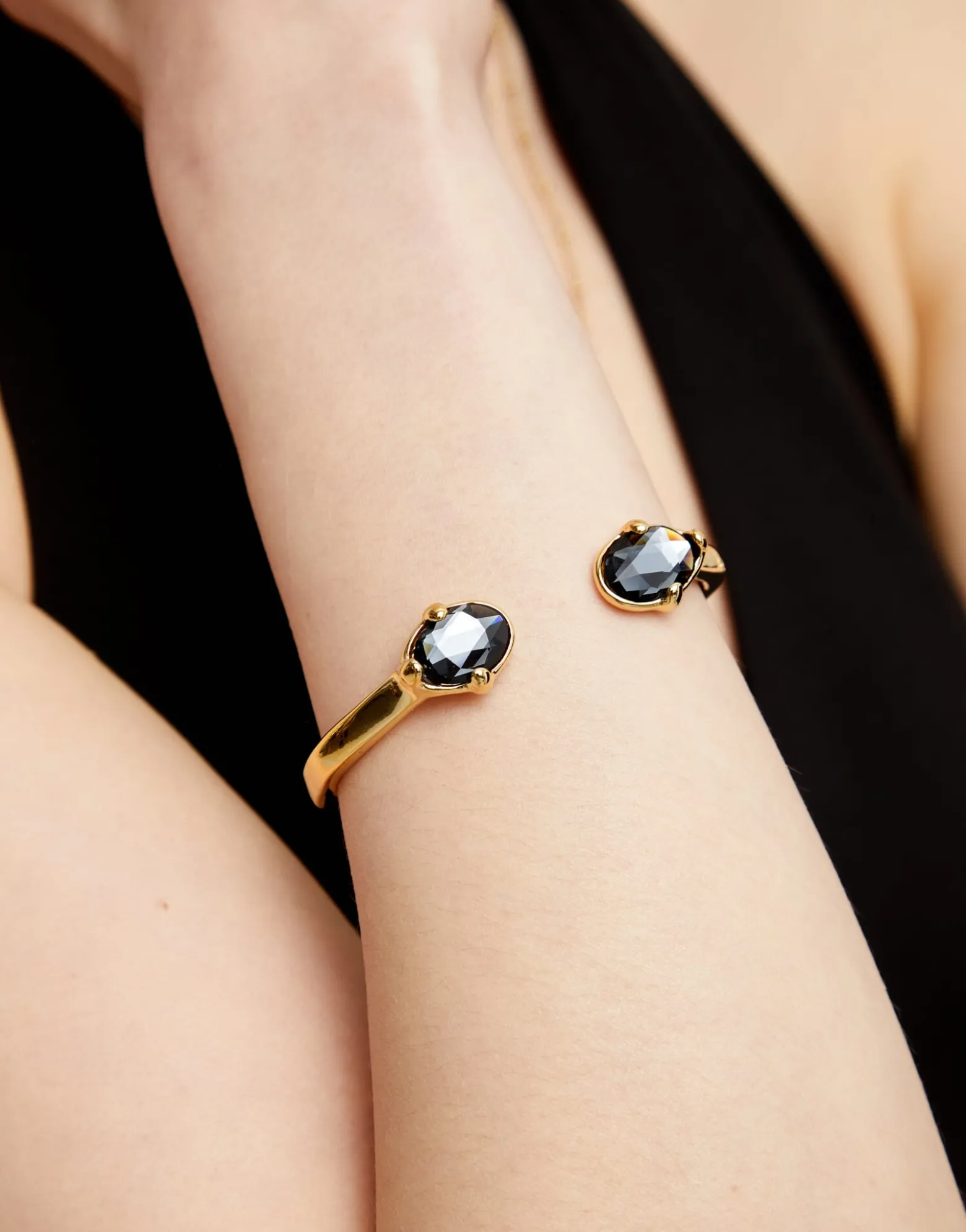 Pulsera rígida bañada en oro 18k con dos cristales facetados ovalados negros