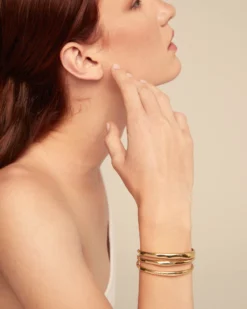 Pulsera rígida triple con curvas bañada en oro
